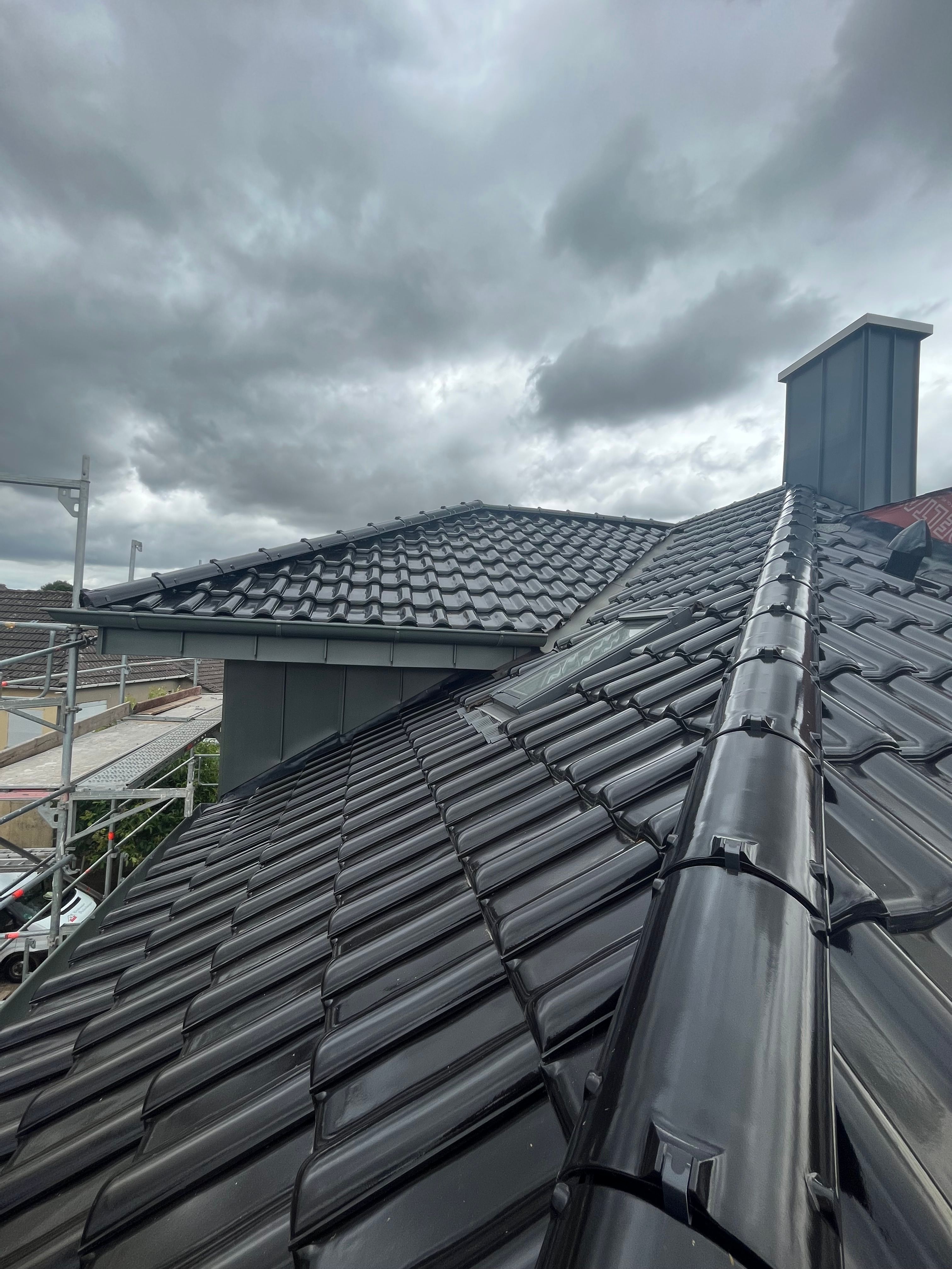 Reihenhausdach, zur Hälfte neu mit dunklen Ziegeln eingedeckt